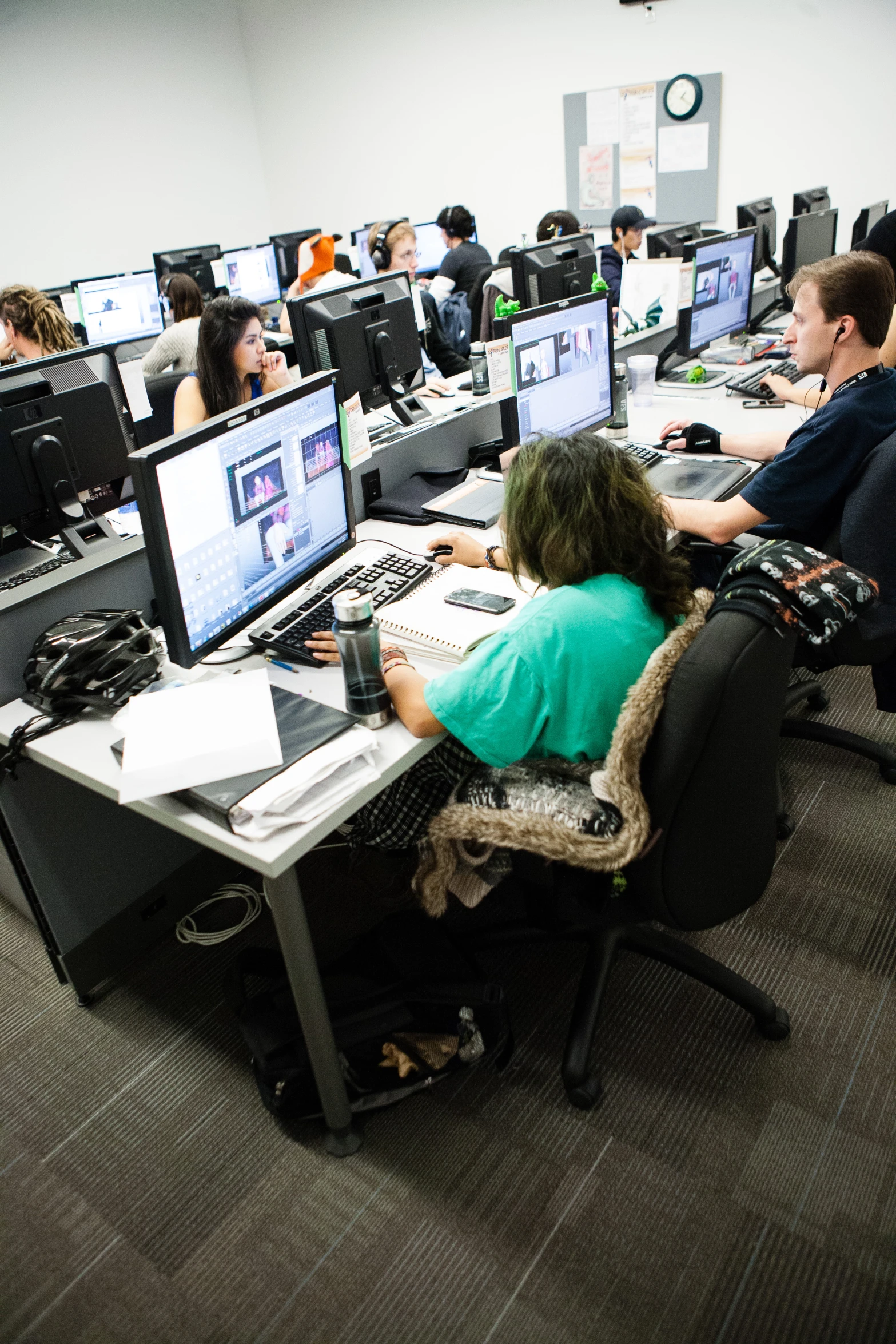 students sit in a computer lab working at computers