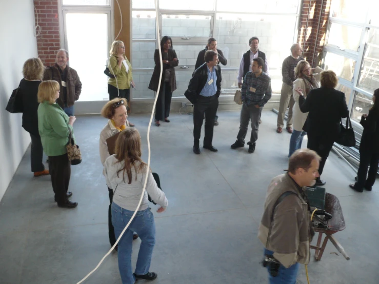 group of people standing in a room one man holding onto a camera