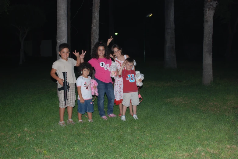 children and adults posing together with a flying disc in the dark