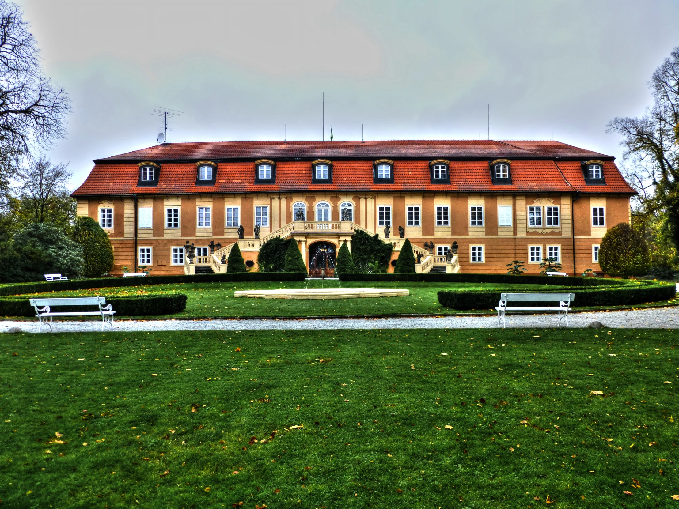 large house in park with some benches on it