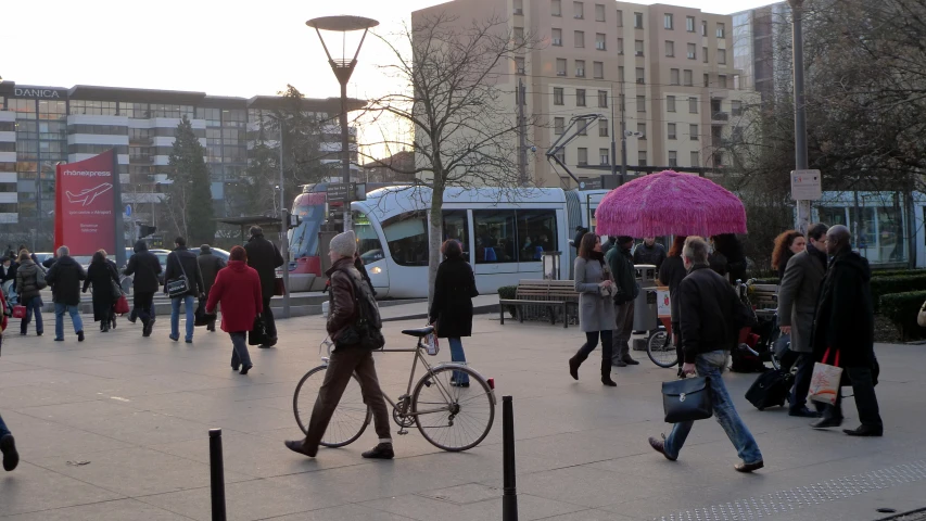 people are walking and playing with umbrellas outside