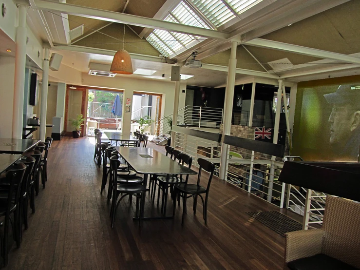 large tables and chairs in a wooden floored dining room