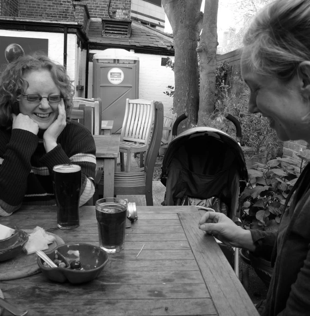 two women sit together having lunch outside