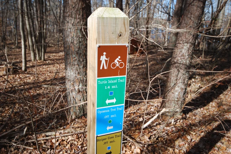 a trail sign is in a wooded area