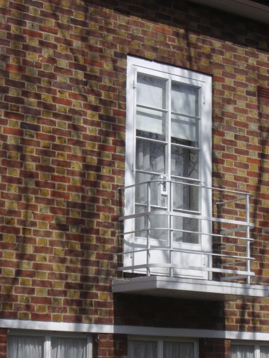 a window and balusty against a brick building