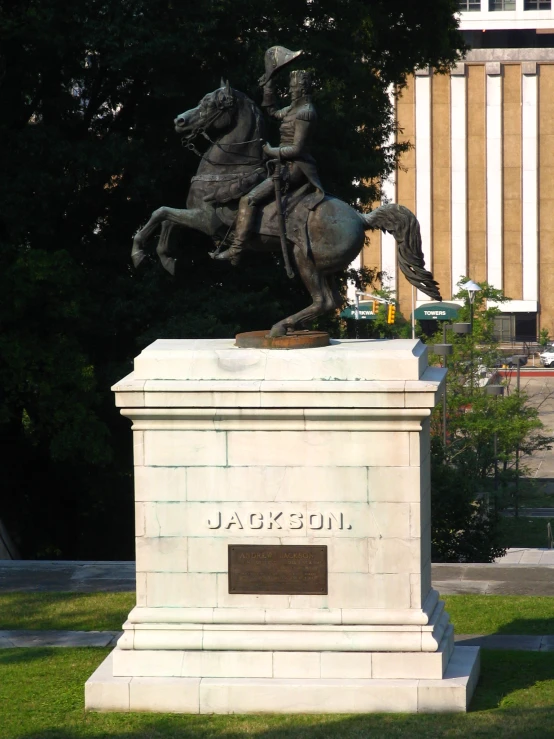 the statue of a man on a horse near a building