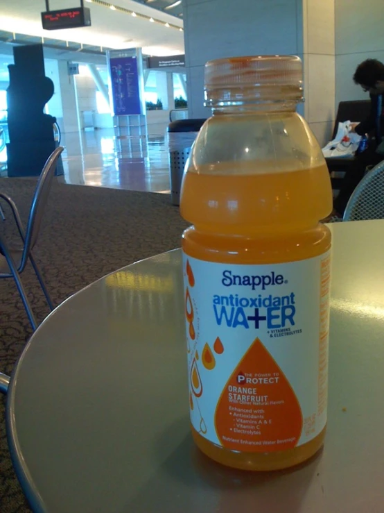 a large bottle of orange water is shown on the table