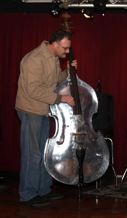 a man playing a contrabason in front of some speakers