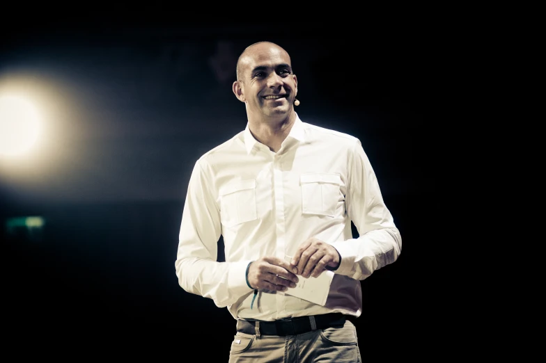 a man wearing an unoned shirt stands in front of a light