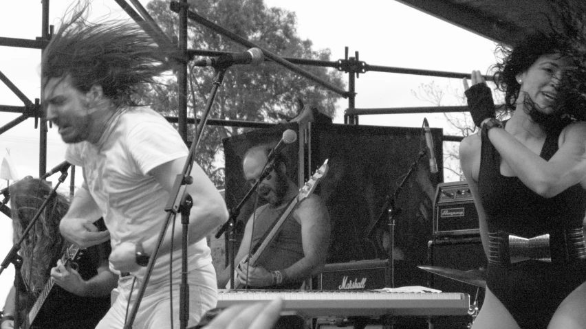 woman standing in front of a man holding his guitar