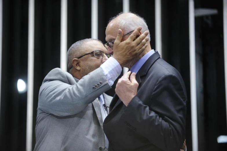 two people dressed up while one holds their hands to his face