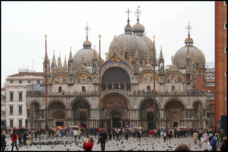 a large building with many domes and birds walking by it