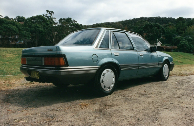 a blue car parked on a dirt lot