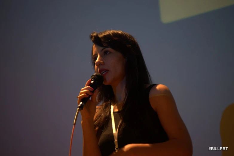 a woman sings into a microphone at an event
