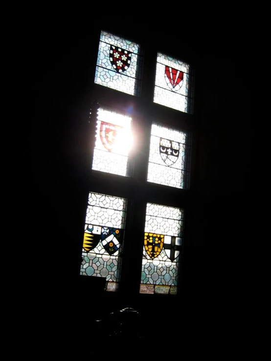 a cross made of stained glass in the dark