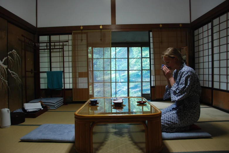 a woman in her pajamas kneeling in front of a table