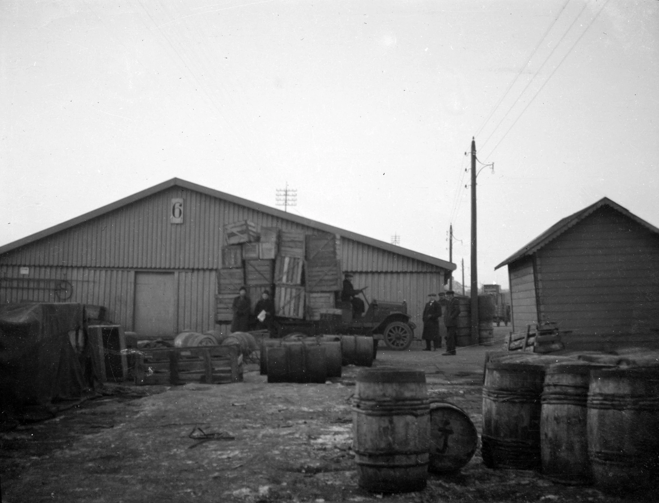 old black and white po of men walking into an open yard