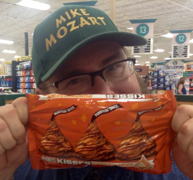 a man holding up a wrapper inside a store