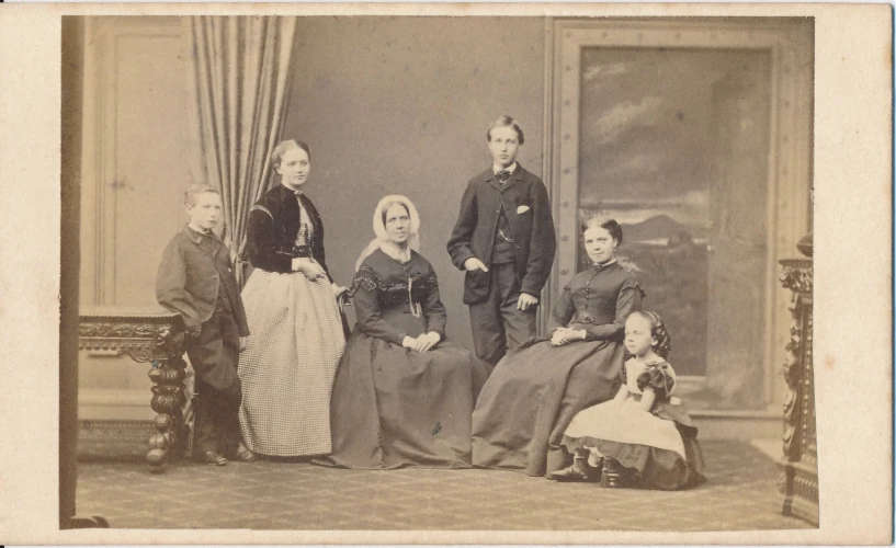 a family is posed together in an old fashion portrait