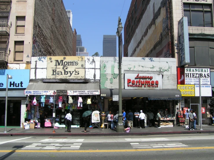 several people with umbrellas standing in front of shops