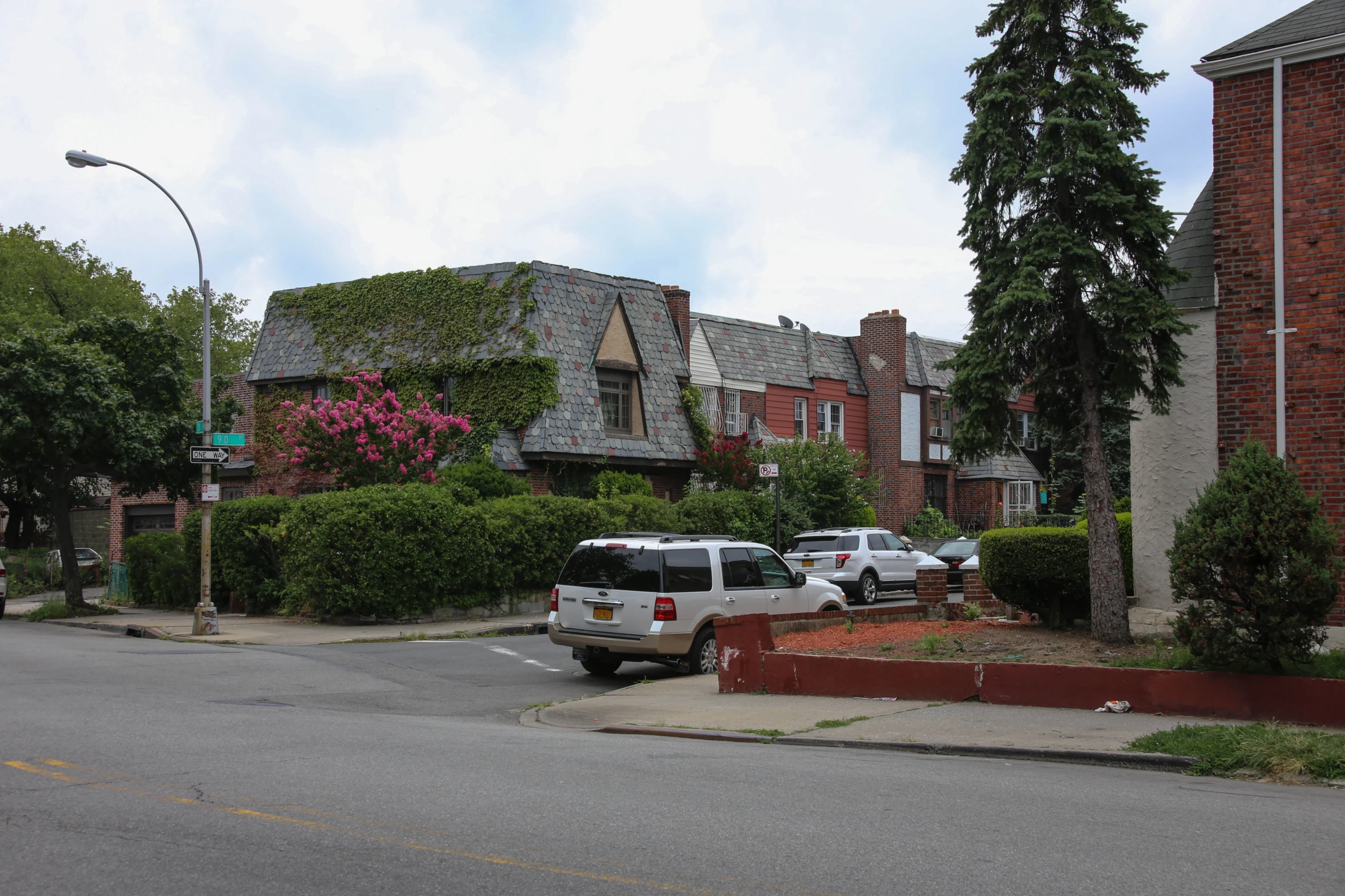 there are cars parked in the street near a red brick building