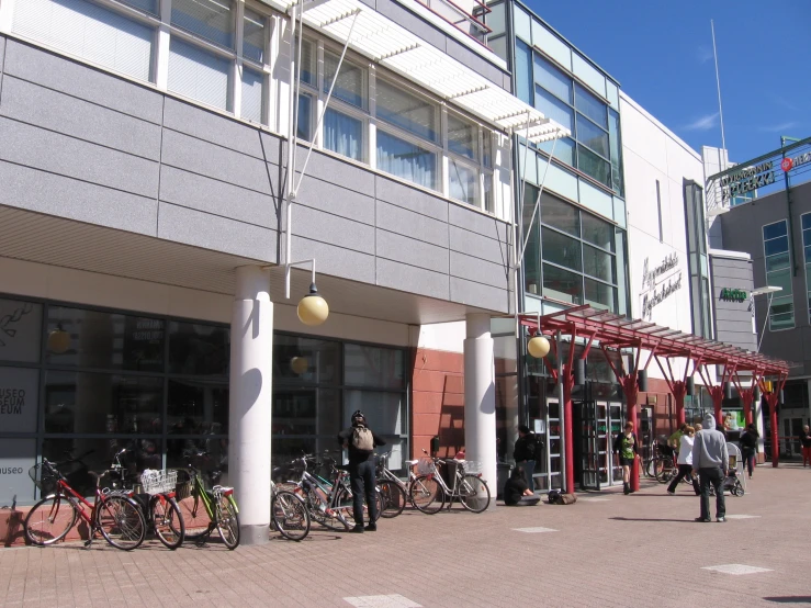 a view of several bikes and people in front of a store