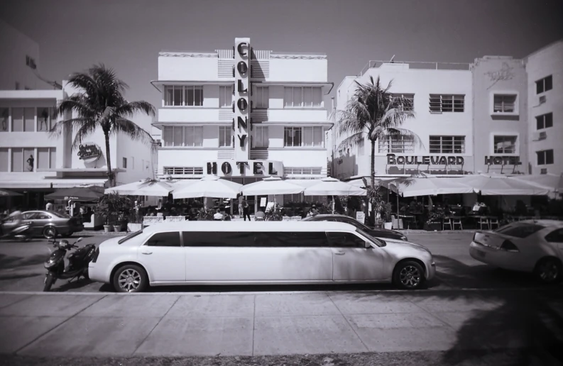 white limousine parked in front of a large building