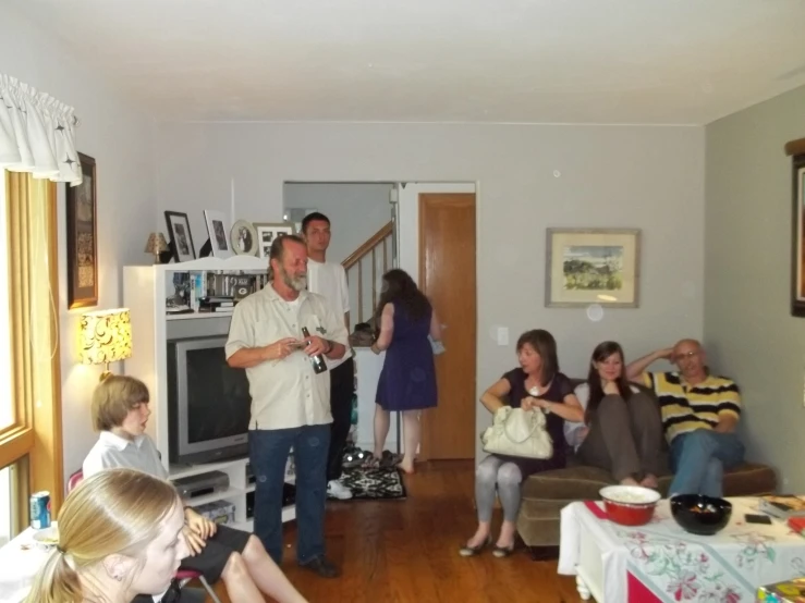 several people in a living room with one of them playing video games