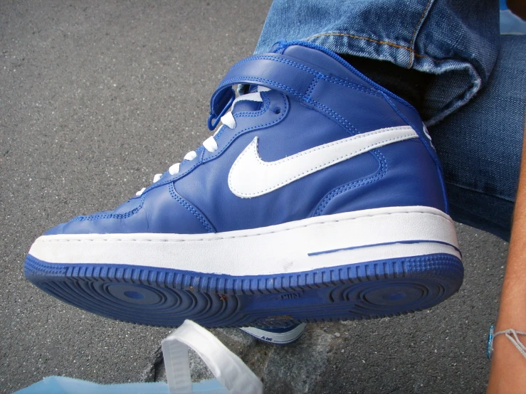 a blue pair of nike sneakers sitting on the ground