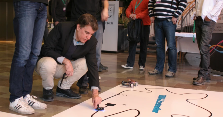 an image of a man kneeling down looking at the phone