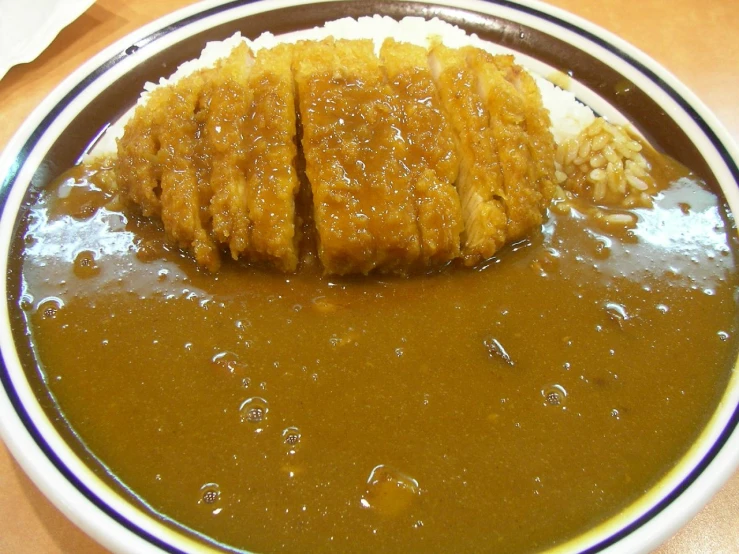 a bowl filled with meat and rice on a table