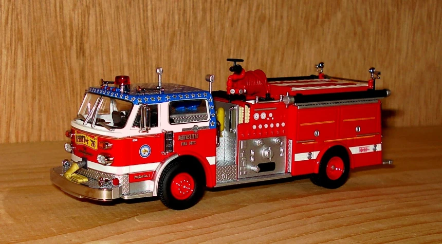 a red fire truck parked on a wooden floor