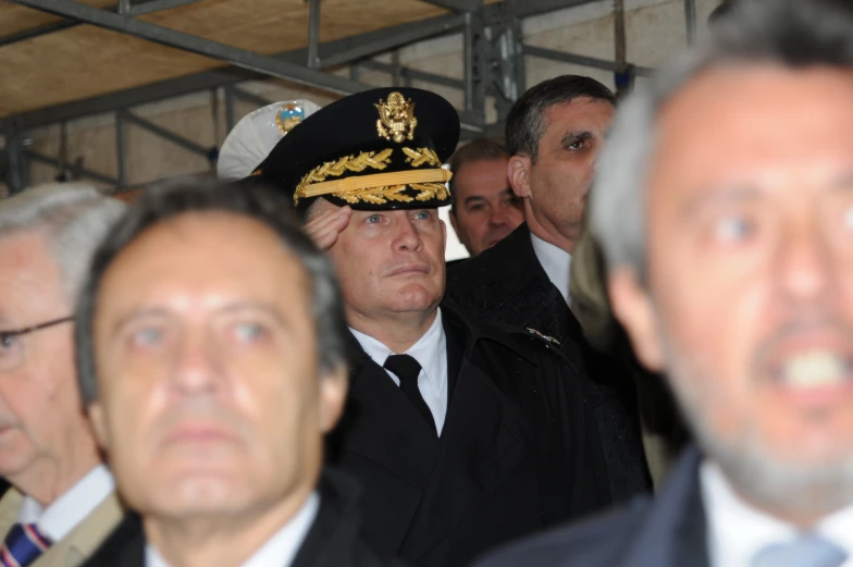 several men wearing military uniforms standing in front of a crowd