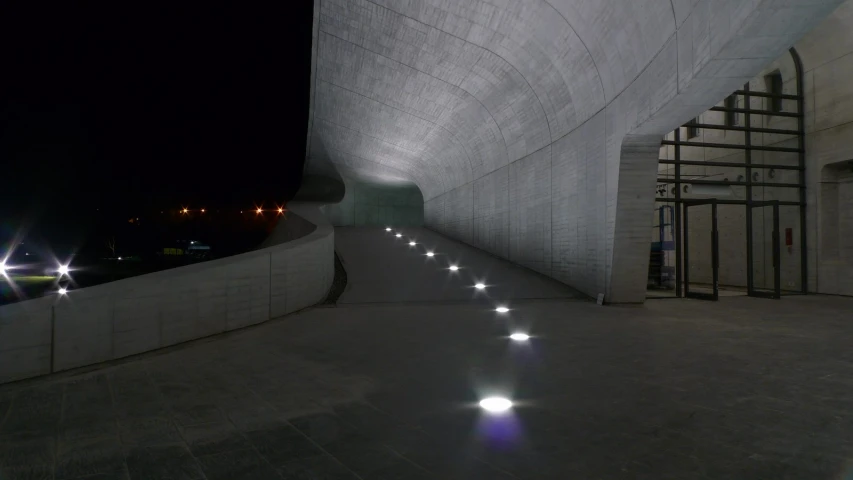 a tunnel made out of concrete with lights in the center