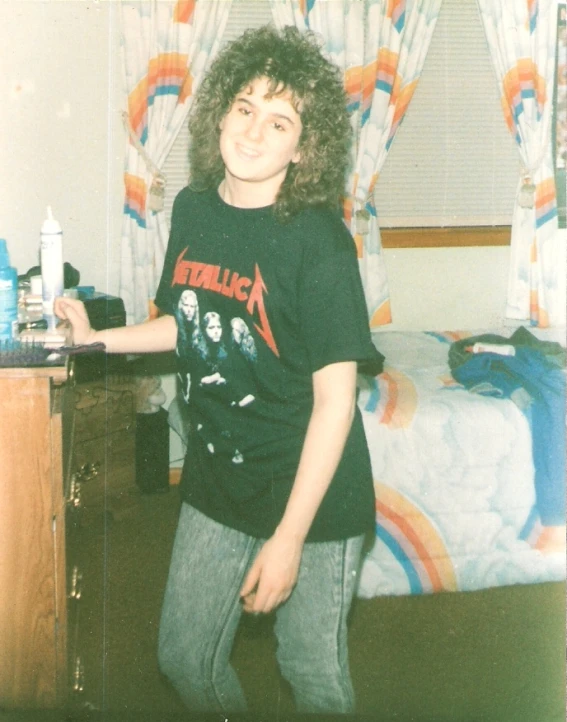 a young man is standing in front of a bed