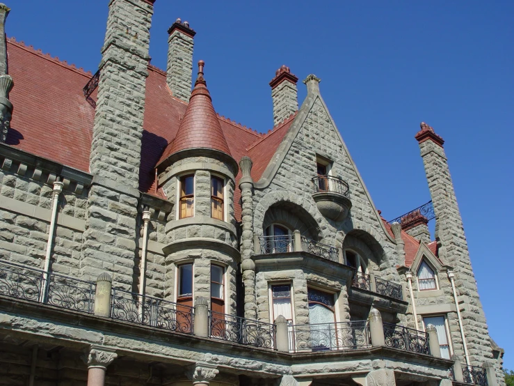 large gray castle type house with brick columns