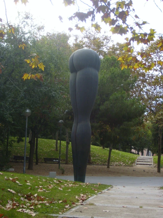 an image of a sculpture of a woman in the middle of the park