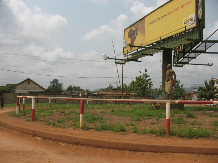 a giant billboard hangs above an empty road