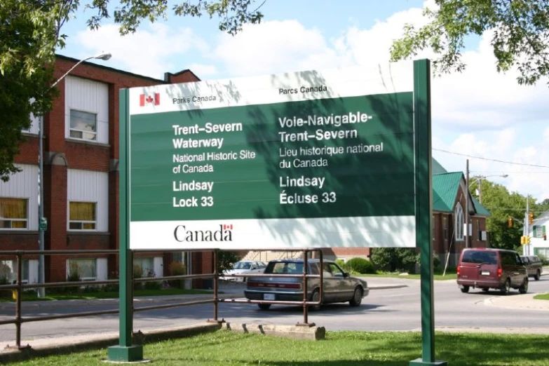 green street sign near a road and brick building