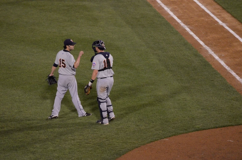 a baseball player talking to another player on a field