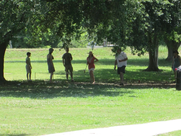 a group of people that are standing by some trees