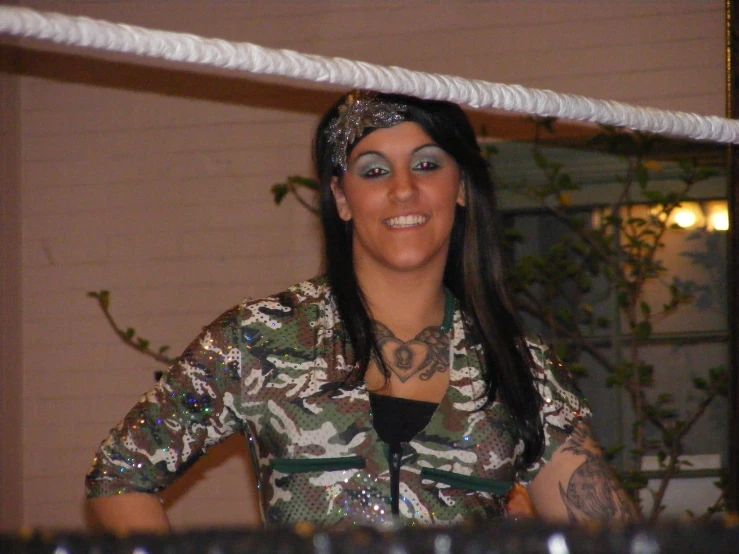 a woman with tattoos and piercings smiling in front of a string