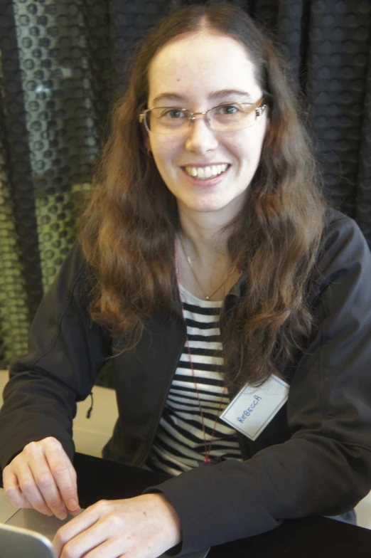 young woman smiling and typing with her laptop