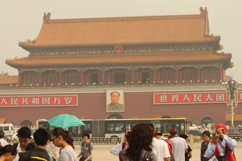 people walking on the street with a huge building in the background