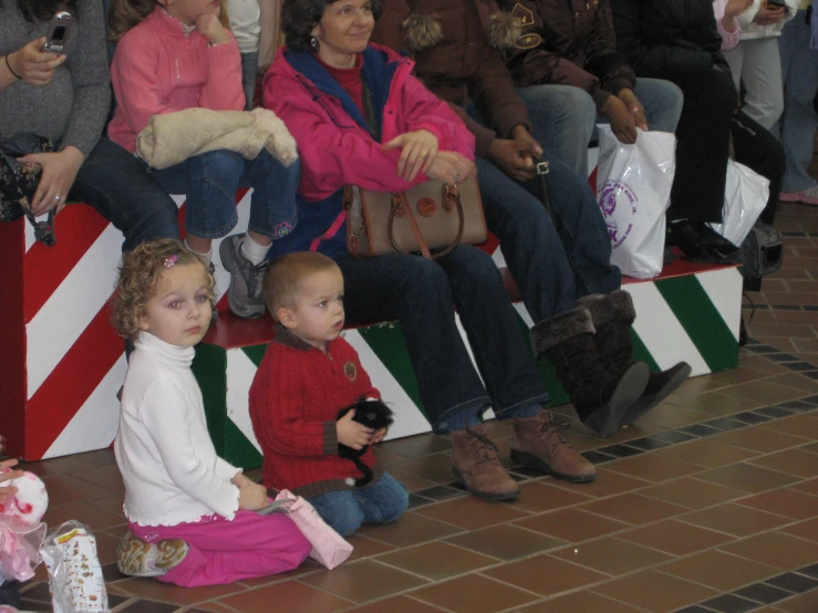 two little girls are sitting and looking at each other