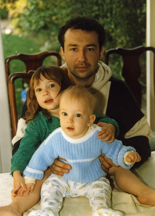 a man sitting next to two small children