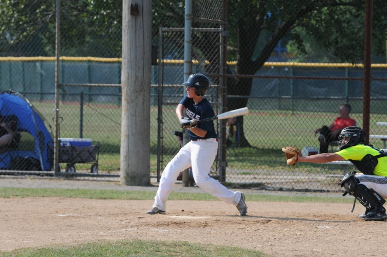 a baseball player at home base about to run with the catcher behind him