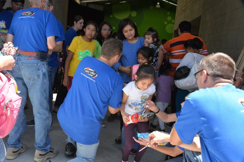 many people standing around some children talking