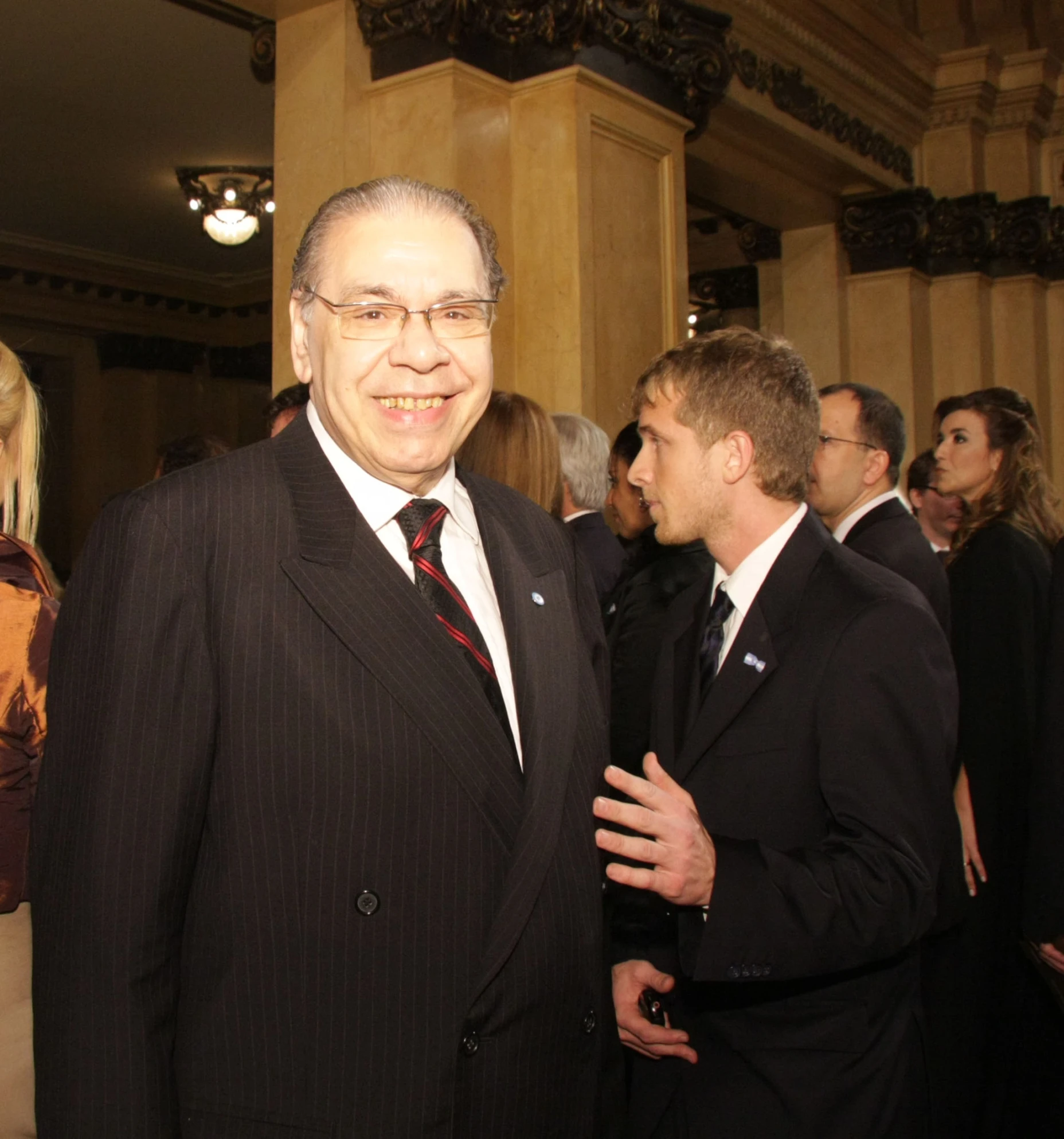 an older gentleman wearing a suit and smiling