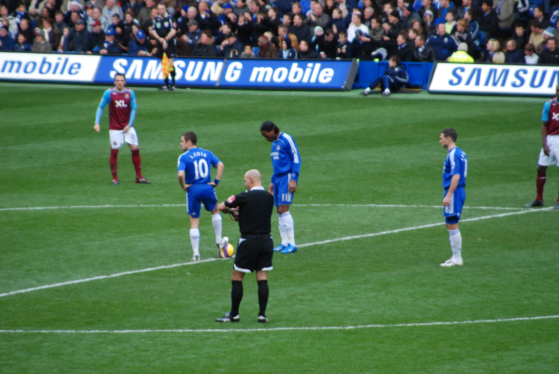 several players at the soccer game one is handing the referee a red card